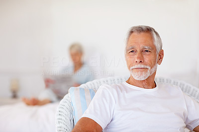 A senior old retired man sitting at home