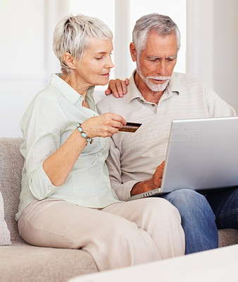 Old couple shopping with their credit card using the internet