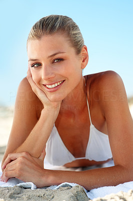 Closeup of a pretty young female in white bikini at a sandy beach
