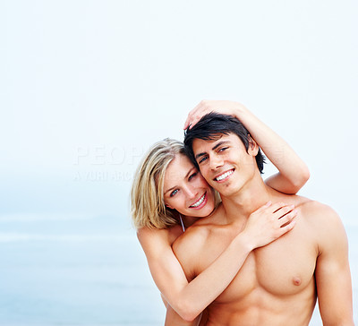 Pretty young woman hugging her boyfriend from behind