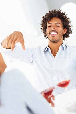 Happy young couple enjoying themselves over a glass of red wine