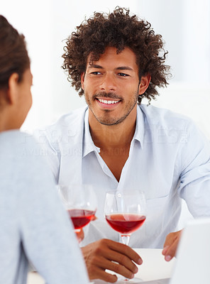 Happy young couple having a glass of red wine together