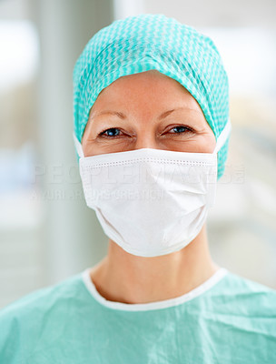 Female surgeon with a face mask and head cap