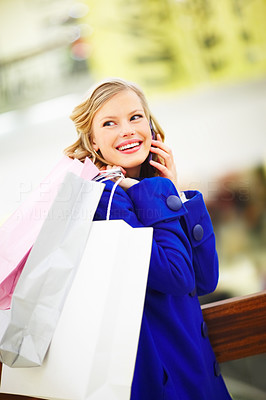 Happy young woman holding many shopping bags at a store