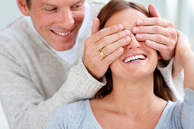 Young man covering a woman's eyes to surprise her