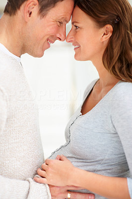 Happy young man holding his pregnant wife\'s belly