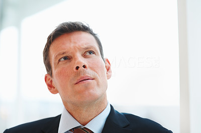 Closeup portrait of a handsome young business man looking at copyspace and day dreaming
