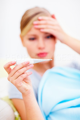 Blurred of a young girl checking her body temperature