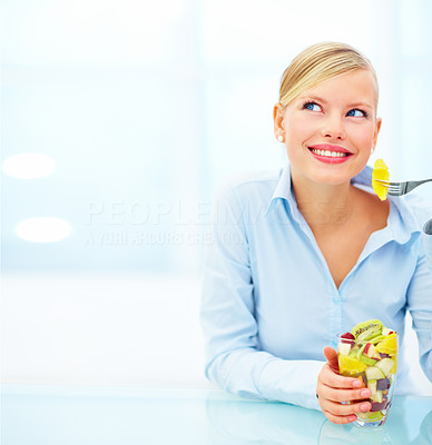 Beautiful woman at desk eating fruit salad sitting in office