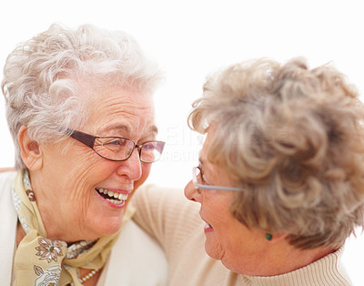 Two mature woman looking at each other and laughing