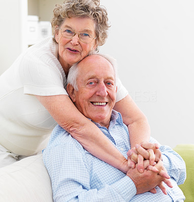 Mature woman hugging old man on couch