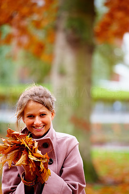 Young charming lady holding maple leaves