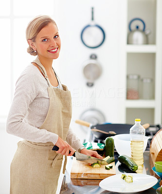 Young beautiful lady cutting vegetables in the kitchen