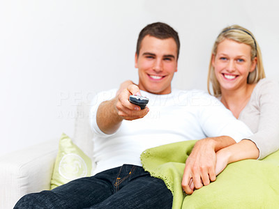 Modern lifestyle - Couple sitting on sofa using remote