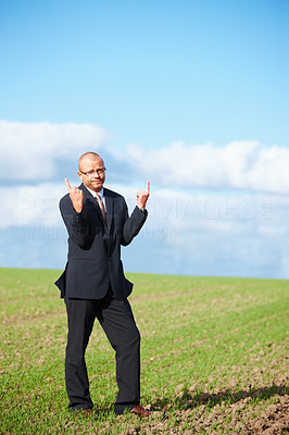 Bored businessman pointing upwards to copyspace