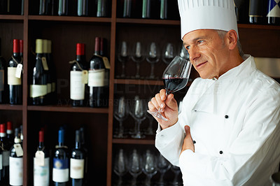 Male chef tasting red wine