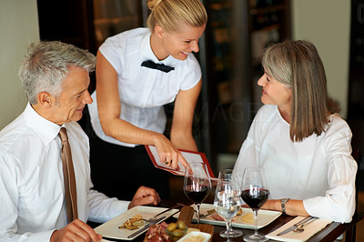 Hospitality - Waitress showing the menu to couple