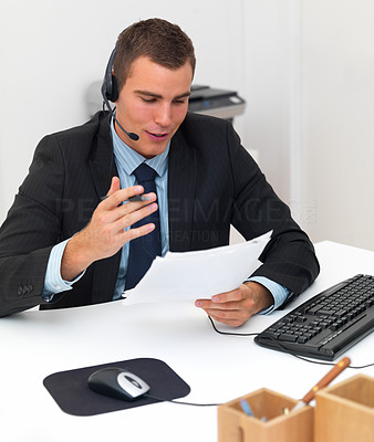 Portrait of a business man talking on a headset in office