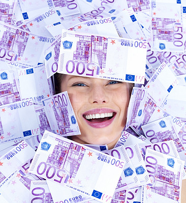 Happy young woman covered in money