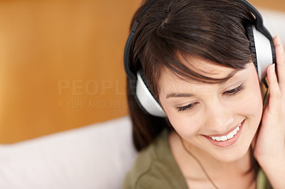 Pretty teenaged female hearing music on headphones