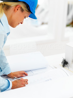 Female architect working on blue prints