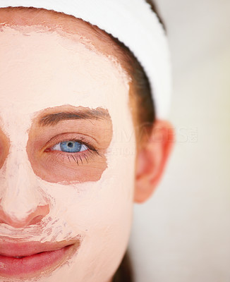 Closeup portrait of a happy beautiful girl with facial mask and blue eye