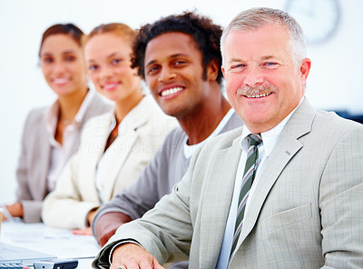 Closeup portrait of a smiling business man with executives against white