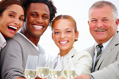 Closeup of smiling business people having champagne against white