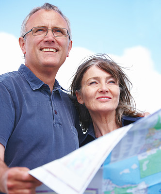 Happy old couple looking ahead with map in hand