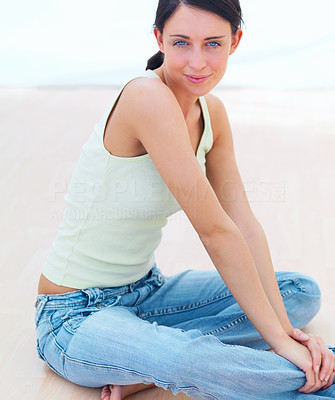 Happy young lady sitting on floor