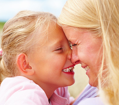 Closeup of a mother and daughter looking at each other and smiling