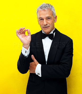 Smart businessman gesturing ok sign on yellow background