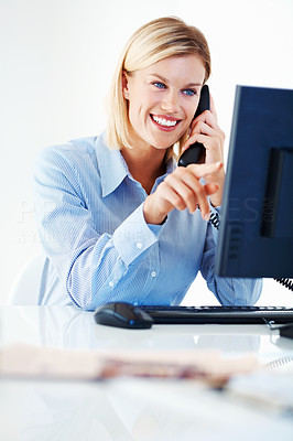 Business woman on call while pointing at computer