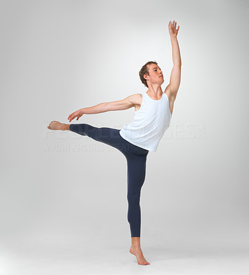 Young ballet dancer performing a balancing act against white