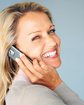Happy woman using a cellphone while giving you a smile