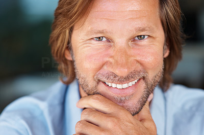 Detail shot of a smiling middle aged man with hand on chin