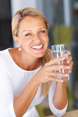 Closeup of a happy mature woman holding a glass of water