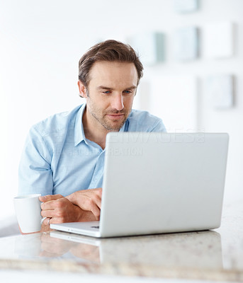 Relaxed young man using a laptop at home
