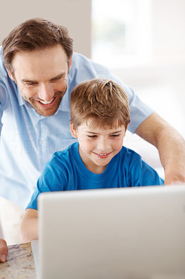 Happy young father and his son using laptop