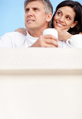 Mature couple having coffee together against sky