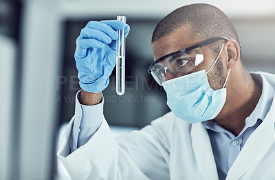 Buy stock photo Shot of a young scientist conducting an experiment in his lab