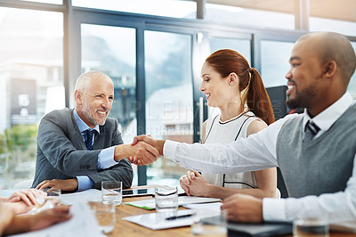 Buy stock photo Cropped shot of two businessmen shaking hands during a meeting