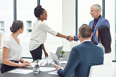 Buy stock photo Cropped shot of businesspeople shaking hands during an office meeting