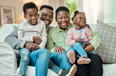 Buy stock photo Cropped shot of an affectionate young family of four sitting on their sofa in the living room at home