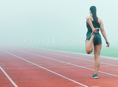 Buy stock photo Rearview shot of an unrecognizable young sportswoman stretching on a running track