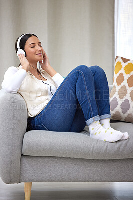 Buy stock photo Shot of a young woman listening to music at home