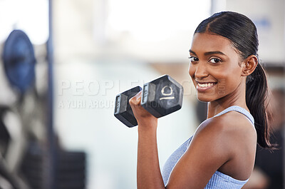 Buy stock photo Portrait of a sporty young woman exercising with a dumbbell in a gym