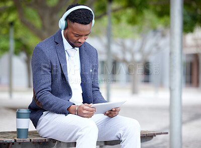 Buy stock photo Shot of a young businessman using a tablet outside in the city