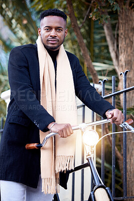 Buy stock photo Shot of a young man standing with his bike in the city