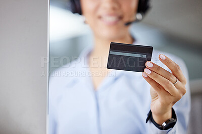 Buy stock photo Cropped shot of an unrecognisable call centre agent sitting and holding a credit card while using her computer